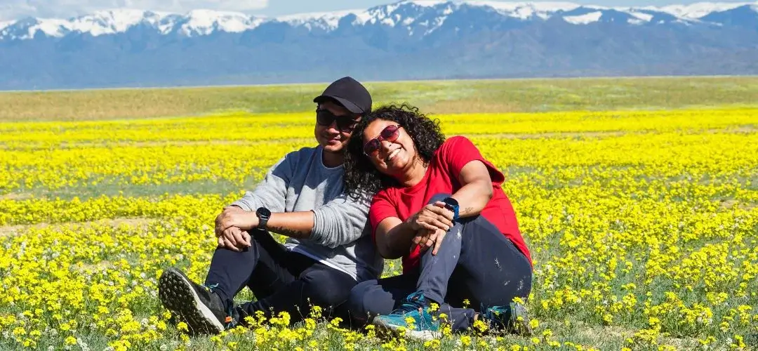 couple posing in the backdrop of snow capped himalayas during their love trip to kashmir