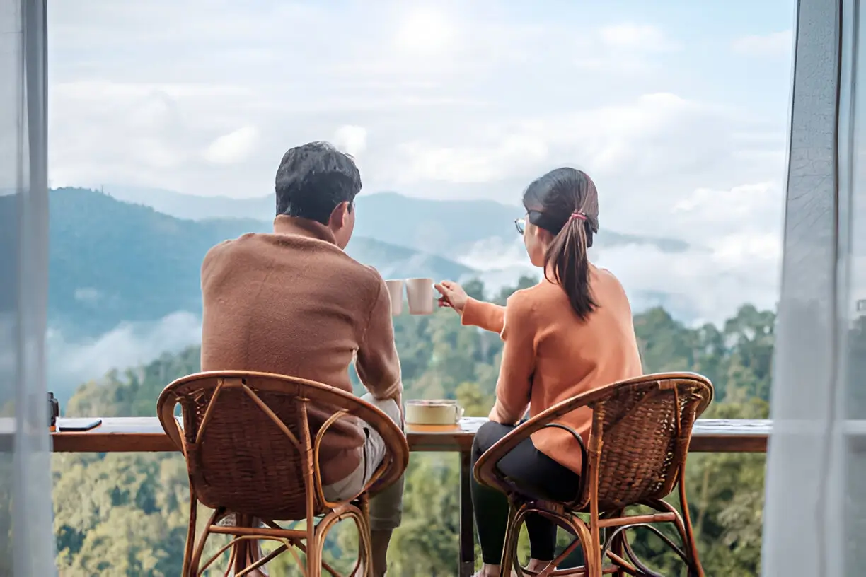 Stunning balcony view from a luxurious Pahalgam hotel, overlooking the Lidder River and snow-capped Himalayas, perfect for couples on Kashmir Nirvana’s Luxury Kashmir Honeymoon Package.