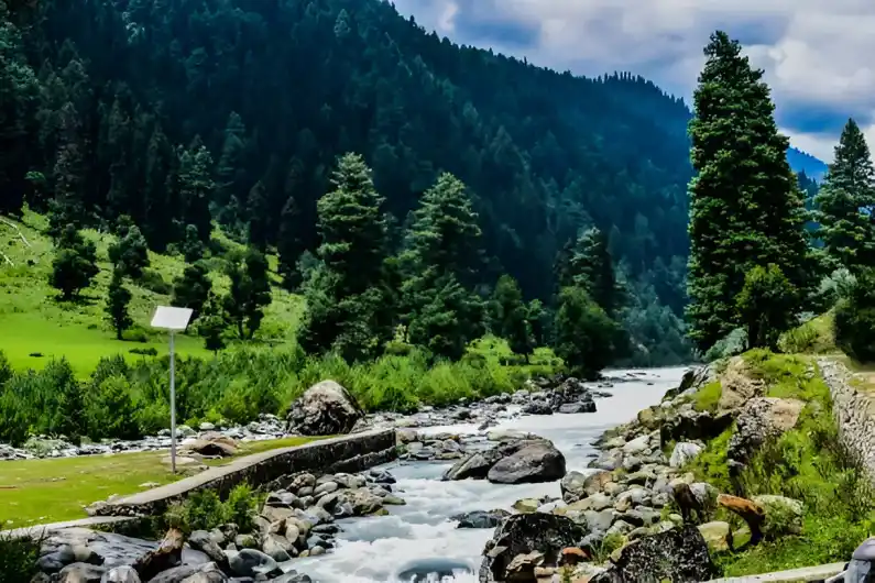  Scenic Lidder River flowing through majestic mountains in Pahalgam, Kashmir, India, a top attraction for tourists on Kashmir Nirvana’s Luxury Kashmir Honeymoon Package.